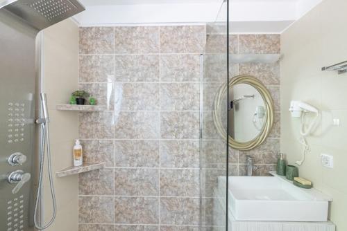 een badkamer met douche, wastafel en spiegel bij Loft Matina in Nafplio