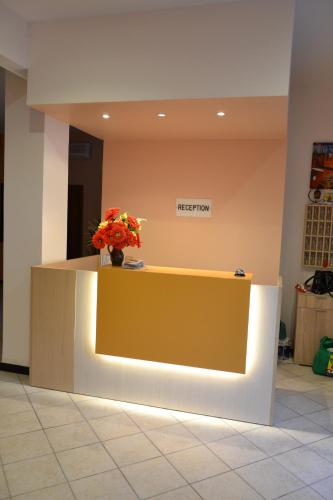 a reception counter with a vase of flowers on it at Hotel Geppi in Pietra Ligure