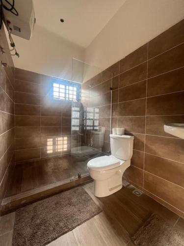 een badkamer met een toilet en een douche bij Big chill stays in Madina