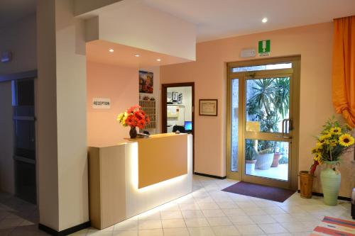 a lobby with a door and a vase of flowers at Hotel Geppi in Pietra Ligure