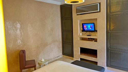 a bedroom with a bed and a tv on a wall at Riad Pourpre Medina in Marrakesh