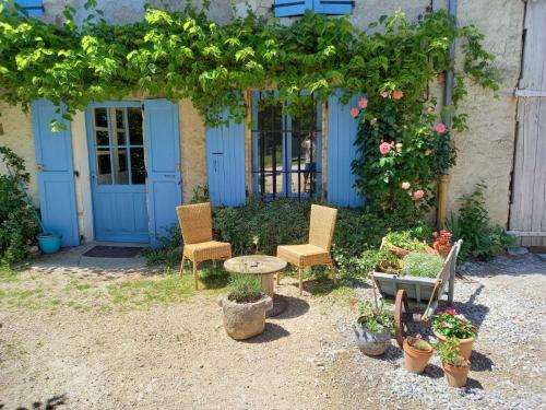 a patio with two chairs and a table and some plants at Gîte La Poule Bleue in Charavines