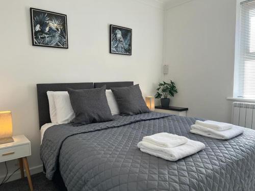 a bedroom with a bed with two towels on it at Flat 2 High Street Apartments, One Bed in Wellington