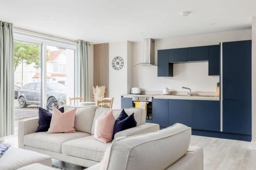 a living room with a couch and a kitchen at Modern 2 bed, cliff top & parking, F6 in Southbourne