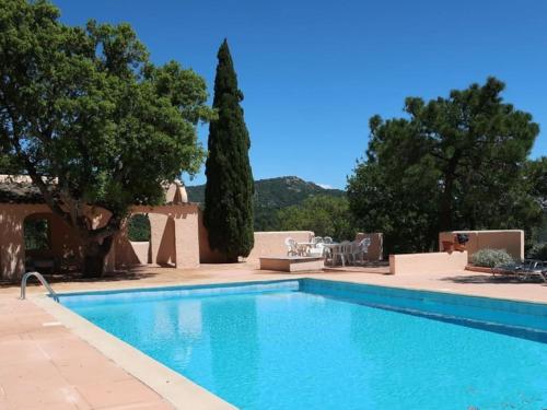 une piscine devant une maison avec des arbres dans l'établissement Studio de charme avec piscine, à Grimaud