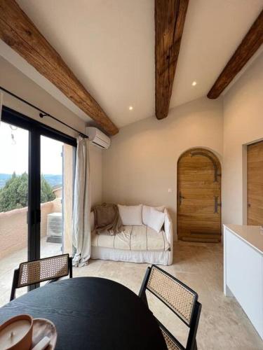 un salon avec un canapé, une table et des chaises dans l'établissement Studio de charme avec piscine, à Grimaud