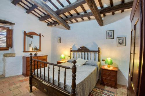 een slaapkamer met een bed, 2 nachtkastjes en een spiegel bij Canapost in Peratallada