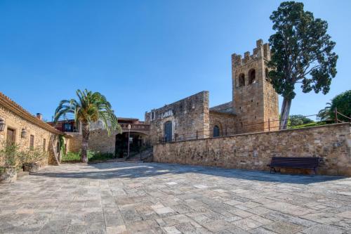 a stone wall with a bench in front of a building at Canapost in Peratallada