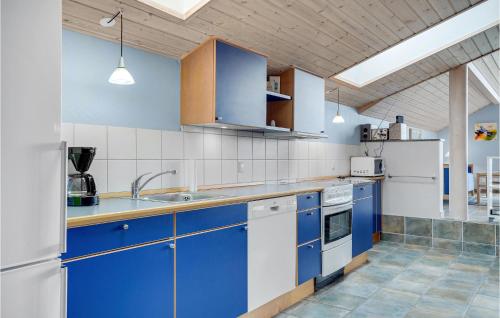 a kitchen with blue and white cabinets and appliances at Holiday Home Juliusvej Gørlev Ix in Reersø