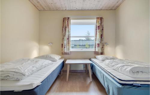 two beds in a room with a window at Nice Home In Grlev With 3 Bedrooms, Sauna And Wifi in Reersø