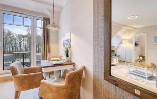 ein Esszimmer mit Tisch und Stühlen und einem Spiegel in der Unterkunft Baltischer Hof Apartment 59 in Boltenhagen