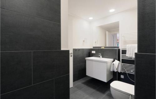 La salle de bains est pourvue de toilettes blanches et d'un mur noir. dans l'établissement Baltischer Hof Apartment 59, à Boltenhagen