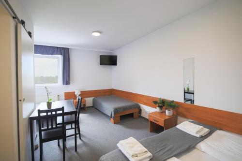 a bedroom with a bed and a desk and a table at Hotel pod Wieliczką in Gdów