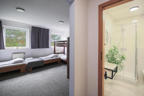 a room with three beds and a walk in shower at Hotel pod Wieliczką in Gdów