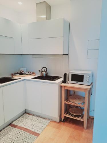 a white kitchen with a microwave on a table at Attico Suite spiaggia Bari in Bari