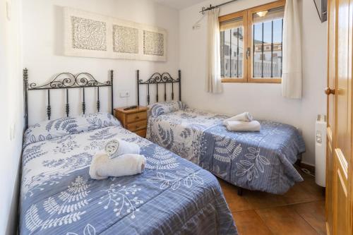 2 Betten in einem Zimmer mit blauer und weißer Bettwäsche in der Unterkunft Carrebaix I in Orba