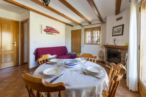 a dining room with a table and chairs and a couch at Carrebaix I in Orba
