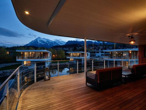 a deck of a cruise ship with a view of the mountains at Deltapark Vitalresort Seevillen in Thun