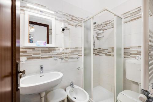 een badkamer met een wastafel, een toilet en een douche bij Monolocale 12 in Pietra Ligure