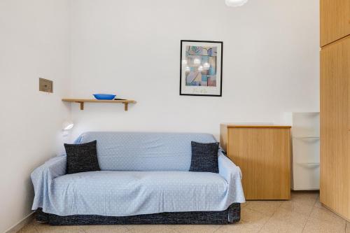 een kamer met een bed met een blauwe deken bij Monolocale 12 in Pietra Ligure