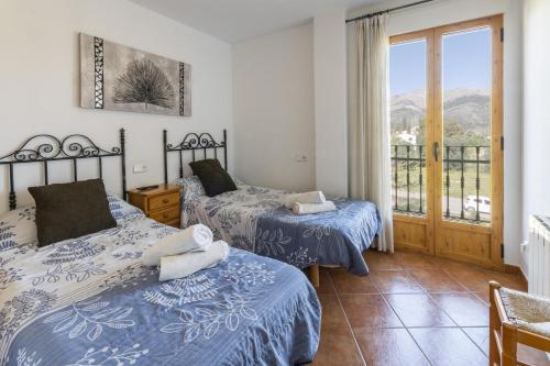 a bedroom with two beds and a balcony at Carrebaix IV in Orba