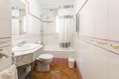 a white bathroom with a sink and a toilet at Carrebaix IV in Orba