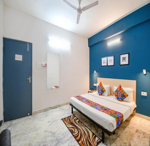 a bedroom with a large bed with a blue wall at FabHotel Silverkey Kalighat in Kolkata