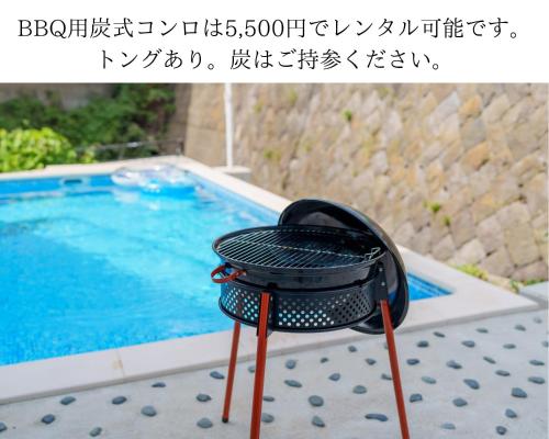 a grill on a table next to a swimming pool at Beachside base KURUWA in Yokosuka