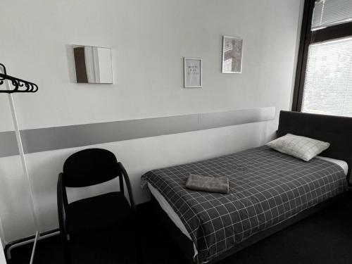 een kleine slaapkamer met een bed en een stoel bij Aleja "Solidarności" in Warschau