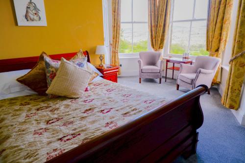a bedroom with a bed and two chairs and a window at Greendale Teahouse and Rooms in Chatburn