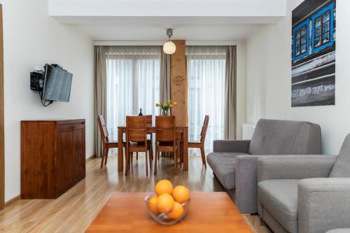 ein Wohnzimmer mit einem Sofa und einem Tisch mit einer Obstschale in der Unterkunft udanypobyt Apartamenty Smrekowa in Zakopane