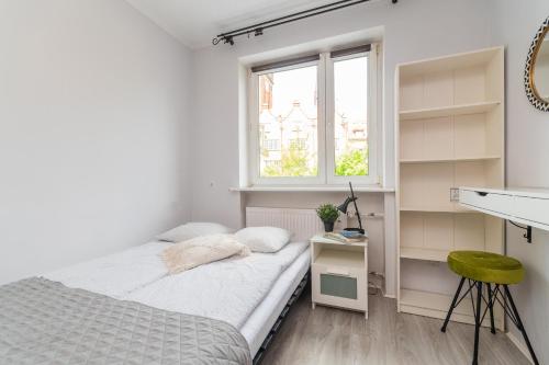- une petite chambre avec un lit et une fenêtre dans l'établissement Bell Tower Old Town Gdańsk Apartment, à Gdańsk