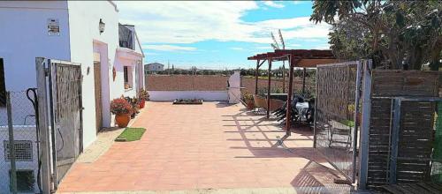 a brick walkway with a gate and a house at Ca Emma in Mahuella