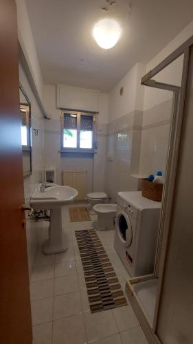 ein Badezimmer mit Toilette, Waschbecken und Waschmaschine in der Unterkunft Cormons Bellissima in Cormòns