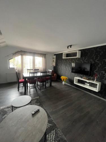 sala de estar con mesa, sillas y TV en Eroilor II Apartament en Suceava