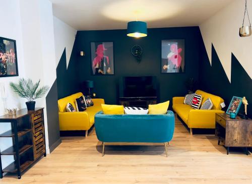 a living room with yellow chairs and a blue couch at KVM - Lavish Style Apartment - Modern 2 Bedroom Apartment in Bayard FREE Parking - KVM Lavish Style Apartment by KVM Stays in Peterborough