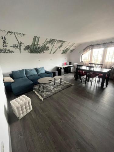 a living room with a blue couch and a table at Eroilor II Apartament in Suceava