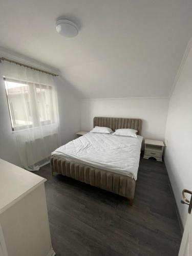 a bedroom with a bed in a white room at Eroilor II Apartament in Suceava