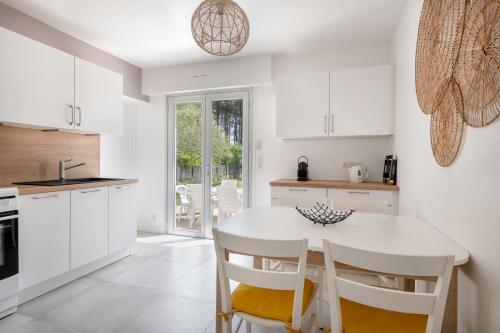 une cuisine blanche avec une table et des chaises blanches dans l'établissement Incroyable emplacement à 110m de la plage, à La Turballe