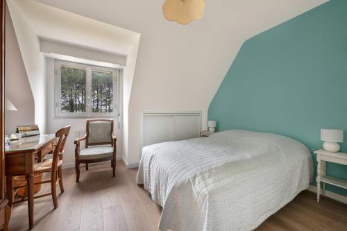 a bedroom with a bed and a desk and a chair at Incroyable emplacement à 110m de la plage in La Turballe