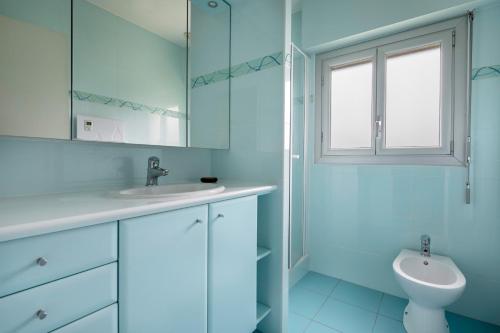 a white bathroom with a sink and a toilet at Incroyable emplacement à 110m de la plage in La Turballe