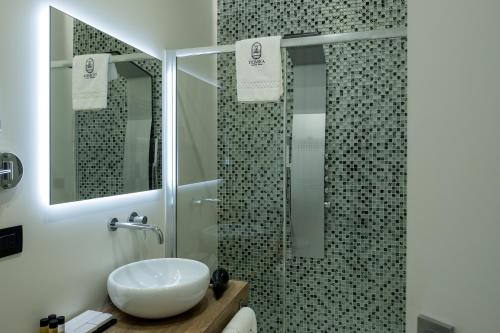La salle de bains est pourvue d'un lavabo et d'une douche. dans l'établissement Domea Superior Rooms Bed and Breakfast, à Reggio de Calabre