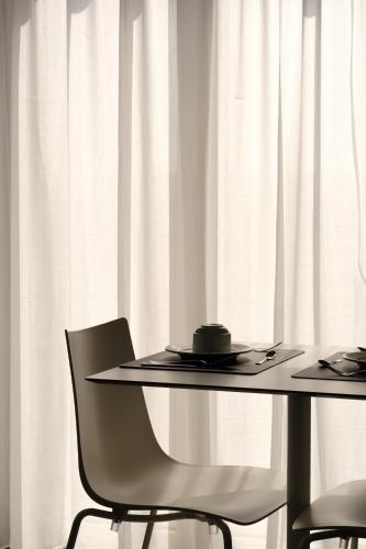 a table and two chairs with white curtains at Domea Superior Rooms Bed and Breakfast in Reggio Calabria