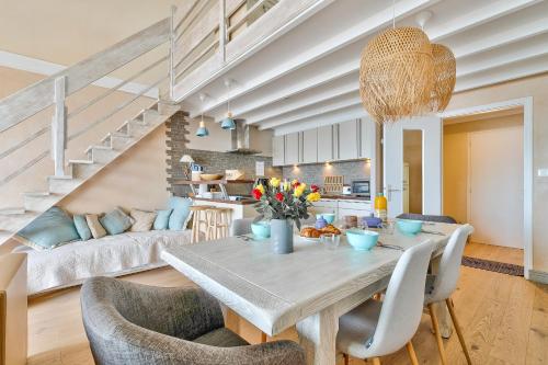 une salle à manger et un salon avec une table et des chaises dans l'établissement Face mer - Emplacement idéal - Appart pour 5, à Noirmoutier-en-l'lle