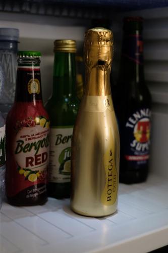 a bottle of beer sitting on a shelf in a refrigerator at Domea Superior Rooms Bed and Breakfast in Reggio Calabria