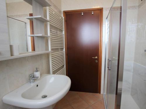 uma casa de banho com um lavatório e um chuveiro com uma porta de vidro em B&B i Casali 