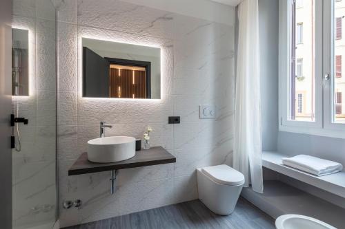 bagno con lavandino, servizi igienici e specchio di Residenza Sacconi a Roma