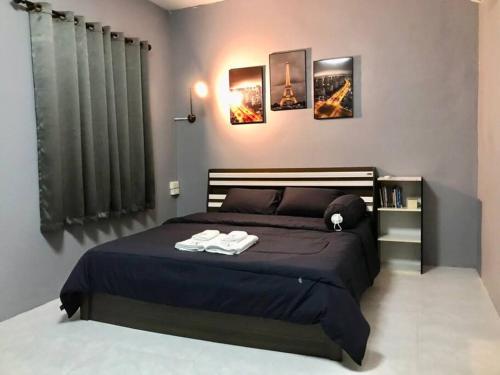Ban Tha Nam Tun的住宿－Walai House วลัยเฮ้าส์ กาญจนบุรี，一间卧室配有一张床,上面有两条毛巾