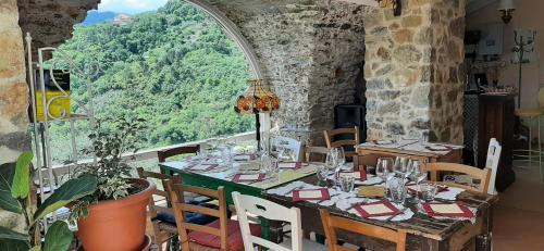 ein Esszimmer mit einem Tisch und einem großen Fenster in der Unterkunft B&B L' Antica Macina in Quiliano