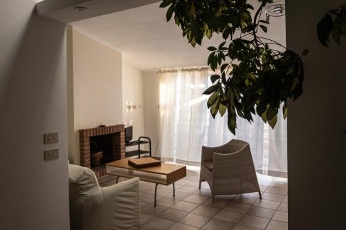 un soggiorno con camino, tavolo e sedie di Chiaro di Luna - Appartamento vista mare a Pisciotta